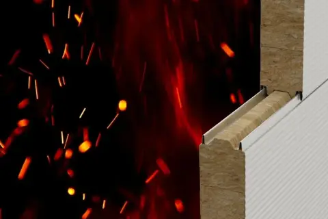 Przekrój materiału budowlanego z wełny mineralnej na tle płonących iskier.